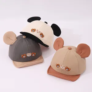 Détail de casquettes bébé à bord souple avec trois ours brodés et des oreilles d'animaux 3D