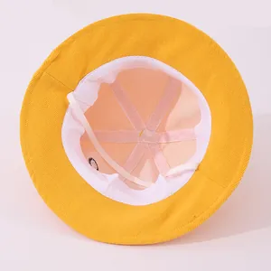 Détail du chapeau bob jaune avec doublure rose et sangle élastique coupe-vent blanche