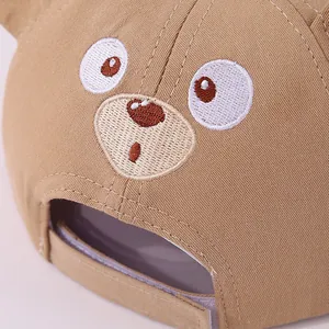 Close-up of cute cartoon bear embroidery and premium cotton texture on khaki baby cap