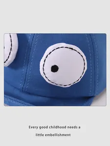 Detailaufnahme der blauen Baby-Baseballkappe mit großer Cartoon-Augen-Stickerei-Applikation