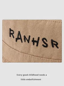 Close-up of khaki canvas kids bucket hat showing detailed black letter embroidery
