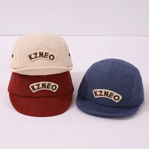 Gros plan des casquettes de baseball bébé en velours côtelé coloris crème, rouge et bleu