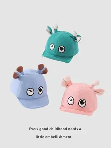 Détail de casquettes bébé en velours côtelé avec yeux de dessin animé et antennes 3D