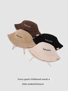 Close-up of kids' cotton bucket hats in four colors with RANHSR letter embroidery