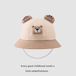 Détail d'un chapeau bob beige pour enfant avec oreilles d'ours et broderie fine