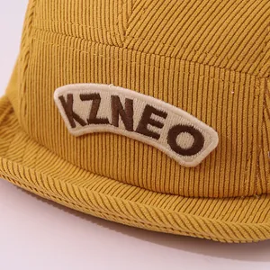 Détail de la casquette bébé en velours côtelé jaune avec écusson brodé KZNEO