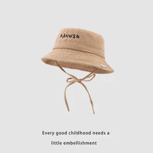 Detail of khaki cotton kids bucket hat with adjustable chin strap and black embroidery