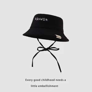 Detail of kids black bucket hat with white RANHSR embroidery and adjustable chin strap