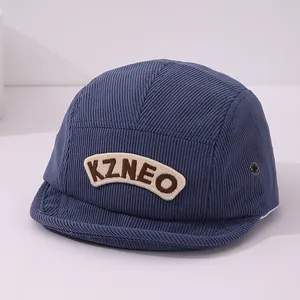 Détail d'une casquette en velours côtelé bleu marine avec écusson KZNEO et œillet métal