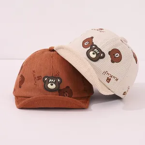 Détail du tissu en velours côtelé doux et écussons d'ours sur casquettes pour tout-petits