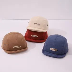 Détail de casquettes en velours pour enfants montrant la texture et la broderie 'nice day'
