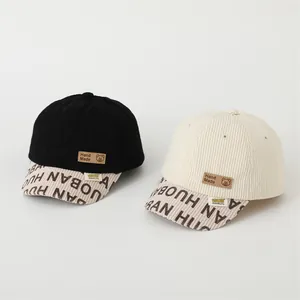 Detail of corduroy baseball caps featuring hand-made leather patches and letter prints