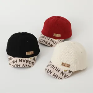 Kids corduroy baseball caps in black, red and beige with bear patch and short brim
