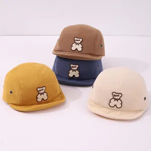 Détail de quatre casquettes de baseball en velours côtelé pour bébé avec ours brodé
