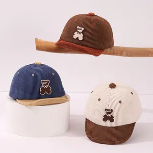 Texture détaillée des casquettes bébé en velours côtelé avec broderie d'ours