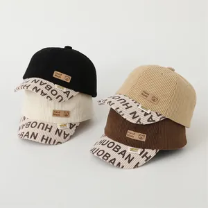 Detailed macro view of multi-color corduroy baseball caps with bear leather patches