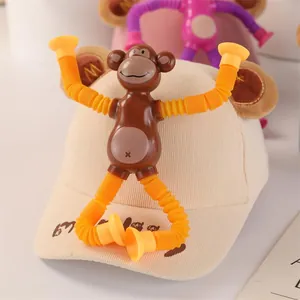 Detail of creative monkey pop tube toy with suction cups attached to a beige child baseball cap