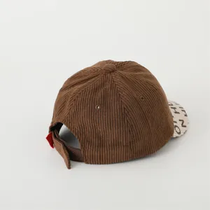 Detail view of corduroy texture on kids baseball cap with adjustable back strap