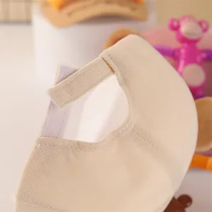 Detail of adjustable velcro strap and beige corduroy texture on the back of the child's cap