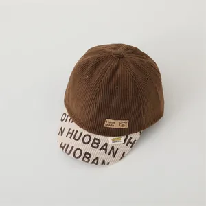 Detail of corduroy kids baseball cap with bear patch and embroidered logo lettering