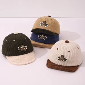 Détail de casquettes en velours côtelé pour bébé avec écussons d'ours en quatre couleurs