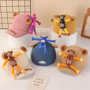 Detail of children's baseball caps featuring detachable telescopic monkey toys with suction cups