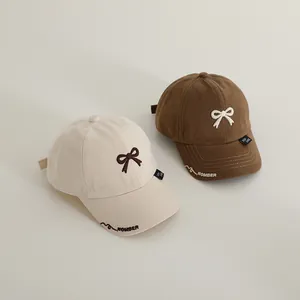 Classic children baseball caps in beige and brown with bow embroidery and adjustable strap