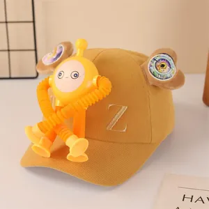 Close-up of yellow corduroy kids cap with cartoon robot toy and letter Z embroidery
