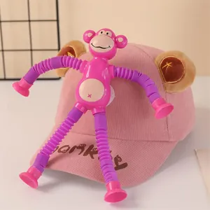 Pink monkey pop tubes toy with suction cups attached to a cute bear ear baseball cap