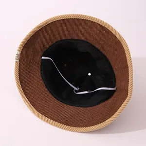 Detail of brown corduroy bucket hat showing inner lining and elastic windproof strap