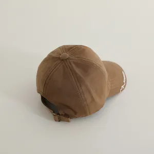 Detail view of cotton baseball cap with adjustable metal buckle and side embroidery
