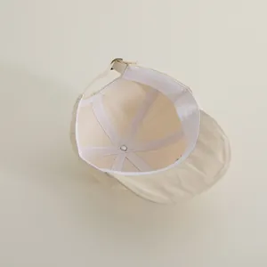 Detailed interior of cotton baby cap showing seams, lining and adjustable metal buckle