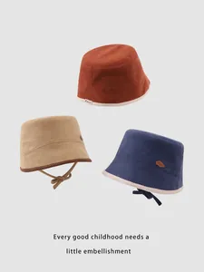 Dettaglio cappelli alla pescatora in velluto per bimbi in ruggine, beige e blu con fiocchi