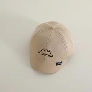 Detail of baby baseball cap with mountain embroidery and black woven brand label