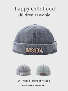 Detail of children's denim brimless caps with Boston embroidery in three blue washes
