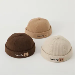 Detail of corduroy docker hats in three colors with Lucky bear embroidery and soft texture