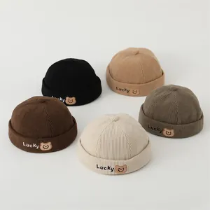 Detail of corduroy docker hats with Lucky bear embroidery in five various colors