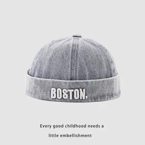 Detail of light blue denim skull cap with white BOSTON embroidery and washed texture