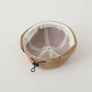 Detail view of khaki corduroy beanie with breathable mesh lining and adjustable cord