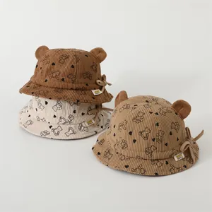 Detailed close-up of corduroy baby bucket hats with bear prints and 3D ear accents