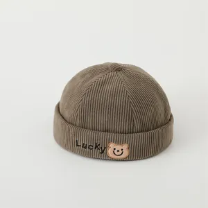 Detail of corduroy melon cap with Lucky embroidery and cute bear patch decoration