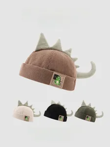 Gros plan sur la texture velours et pointes de dinosaure 3D sur bonnet enfant melon