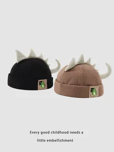 Détail de bonnets dinosaure en velours pour enfants avec pointes en peluche et queue