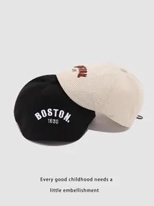 Detalle de la textura de boinas de pana para niños en negro y crema con bordado Boston
