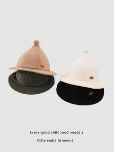 Detail of children corduroy pointy bucket hats in four colors with pom-pom and leather patch