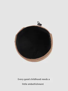 Détail d'un bonnet enfant en velours marron avec doublure noire et cordon réglable