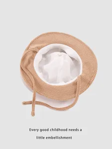 Detail view of khaki corduroy kids bucket hat with white lining and adjustable chin straps