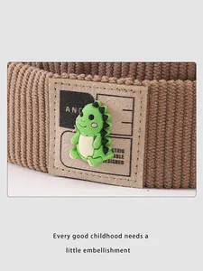 Détail du tissu en velours côtelé avec applique de dinosaure vert sur chapeau enfant