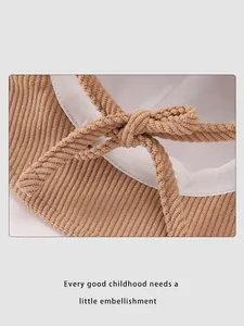 Close-up of brown corduroy children's hat showing bowtie ribbon and quality stitching