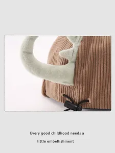 Détail du chapeau enfant en velours marron avec cornes de dinosaure et cordon réglable